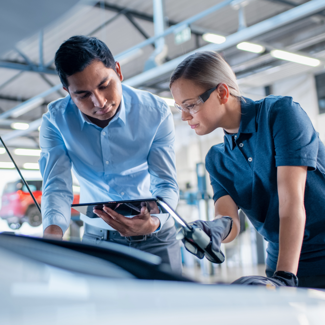 a man and women inspecting a car engine