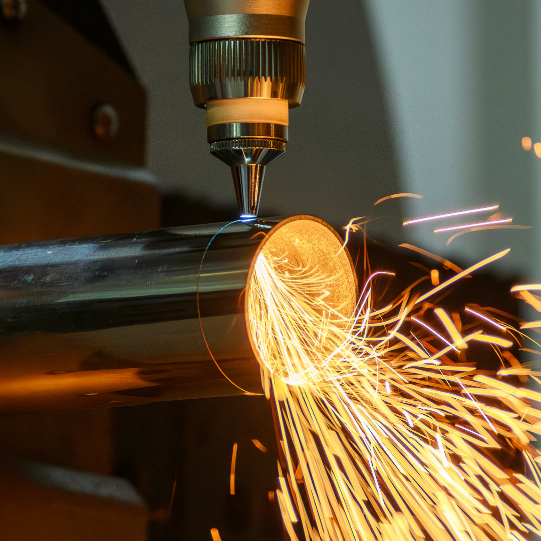 a metal pipe in a fabrication machine with fire sparks coming out