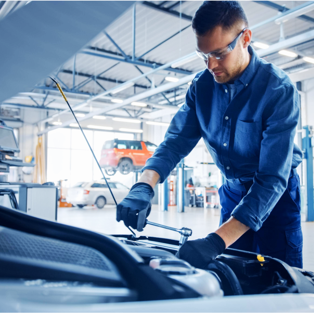 a man fixing a car engine in a garage workshop