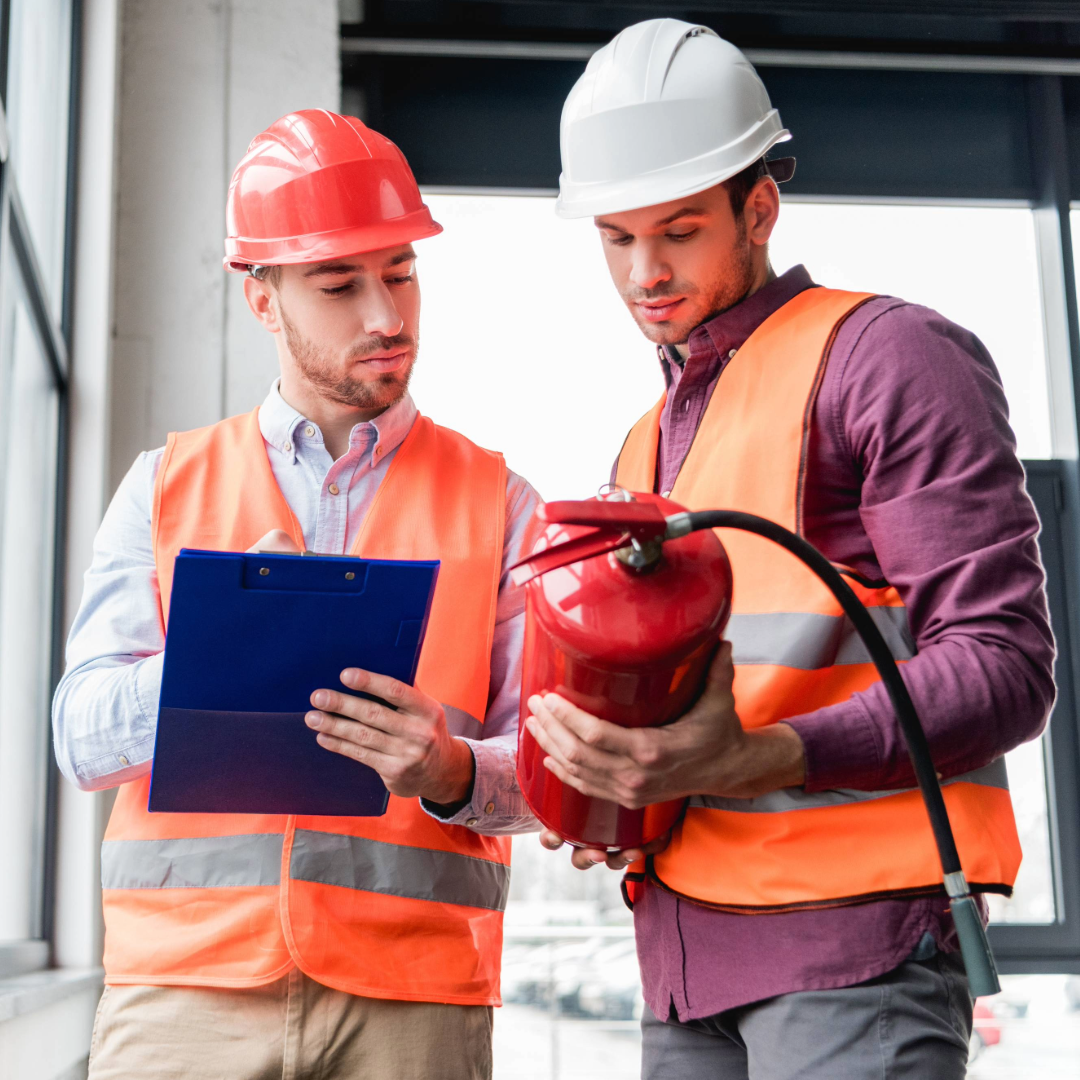 two workers checking a fire extinguisher