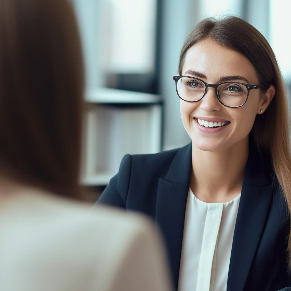 a women smiling and sitting opposite another women