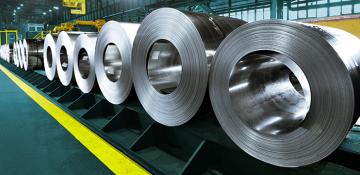 Image shows large reels of steel lined up within a warehouse 